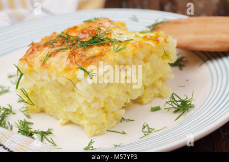 Gratin with pasta, beaten eggs, and cheese, plated with dill Stock Photo