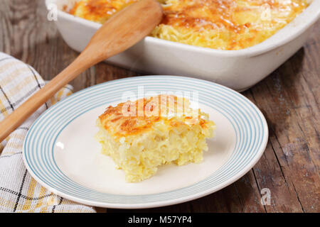Gratin with pasta, beaten eggs, and cheese, on a plate and in white casserole Stock Photo