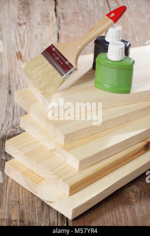 Brush and paints on stack of wooden planks Stock Photo