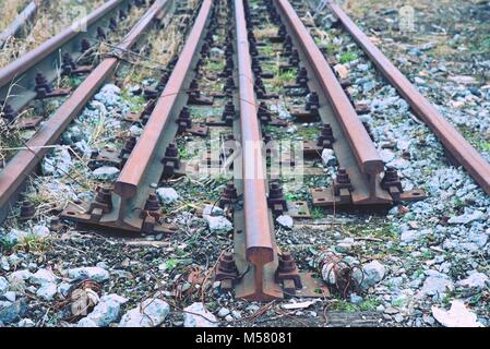 Abandoned rusty rails. Steel rails at old closed railway station.  Metal material is waiting for transport to steel foundry for recycling. Stock Photo