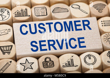 Full frame shot of customer service text on wooden block surrounded by various computer icons Stock Photo