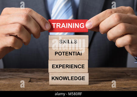 Closeup of businessman building training concept with wooden blocks on wood Stock Photo