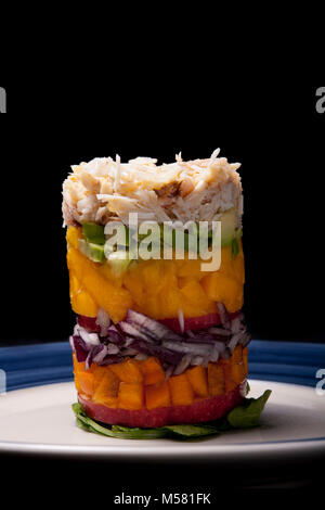 A mixture of apple, persimmon, red onion, mango, and avocado topped with spider crab, Maja squinado, Dorset England  UK GB Stock Photo