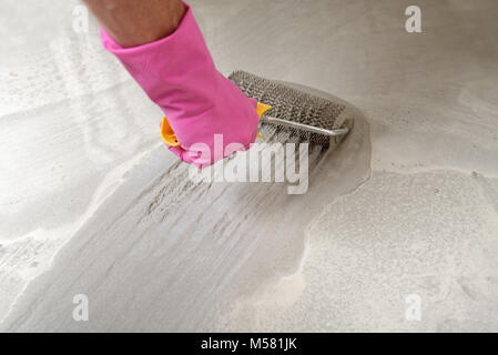Leveling the floor using spiked roller Stock Photo