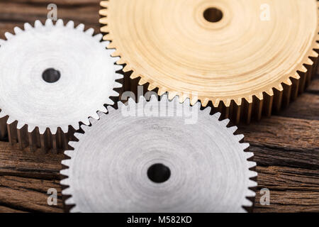 Closeup photo of three interlocking metal gears Stock Photo