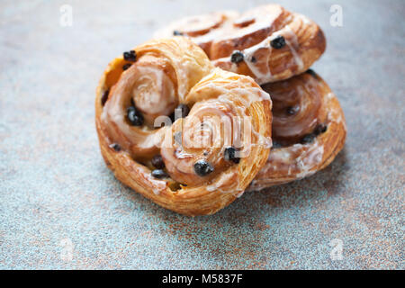 Fresh buns with raisins and icing on old rusty background. Stock Photo
