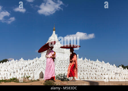 Two novice monks, a girl and a boy, in front of Hsinbyume white Pagoda,near Mandalay,Myanmar Stock Photo