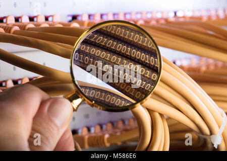Cropped image of hand examining binary codes over cables in server room Stock Photo