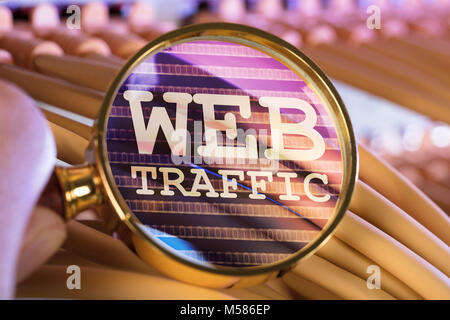 Cropped image of hand analyzing web traffic through magnifying glass over cables in server room Stock Photo