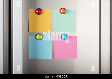 Closeup of blank notes attached with colorful magnetic thumbtacks on metal Stock Photo