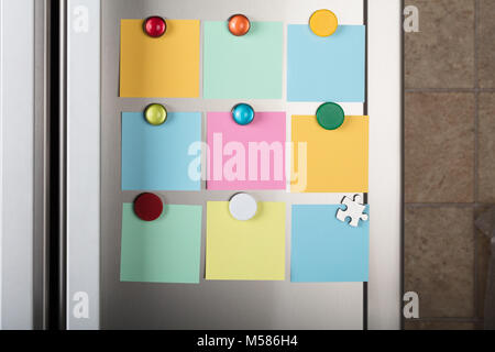 Closeup of blank notes attached with colorful magnetic thumbtacks on metal Stock Photo