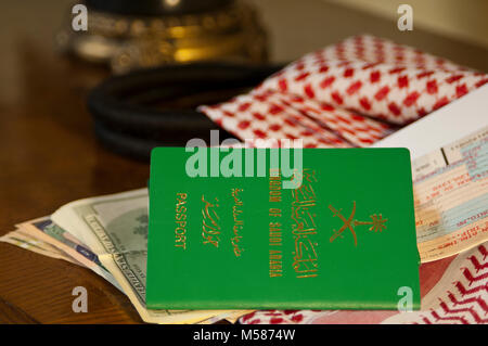 Saudi Traveler Document Passport Flight Ticket Saudi Riyals Money and American Dollars Still Life with Shumagh Head Cover Stock Photo