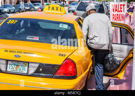 Miami Beach Florida,Ocean Drive,taxi,taxis,cab,cabs,fare,yellow,Black Blacks African Africans ethnic minority,man men male adult adults,enters,public Stock Photo