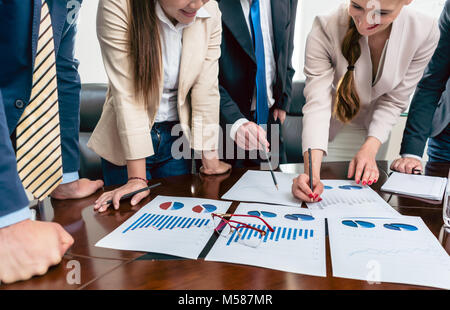 Close-up of eyeglasses with red frames on a printed bar chart, showing progress during a meeting of business analysts in the office of a successful co Stock Photo