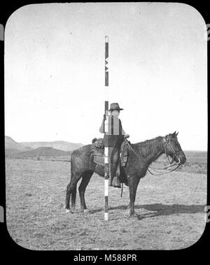 Grand Canyon Matthes Survey of . BLACK AND WHITE GLASS LANTERN SLIDE OF MAN ON HORSE WITH TEN-FOOT-HIGH SURVEYOR'S POLE.  USGS LABEL ATTACHED. CIRCA 1902. WITH A GROUP OF SLIDES FROM THE MATTHES SURVEY EXPEDITION IN THE GRAND CANYON - CIRCA 1902 Stock Photo