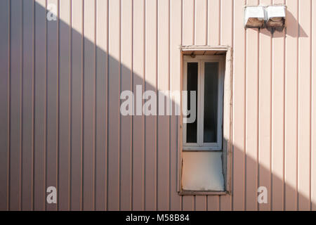 Painted metal pink wall with diagonal shadow and window. Shadow concept Stock Photo