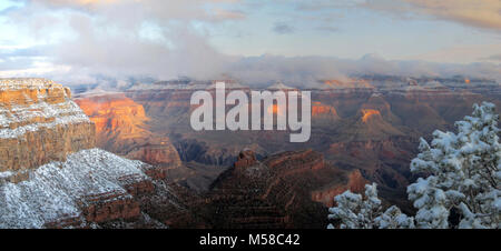 Grand Canyon National Park Sunrise Early December Storm. (6000 x 2741) Friday morning, December 2, 2011. (7:46 a.m.) View looking north from El Tovar Hotel. Several inches of snow fell yesterday and through the night. A slow moving winter storm will continue to produce snow and low elevation rain across the region today.  Winter conditions on the South Rim can be extreme. Be prepared for snow, icy roads and trails, and possible road closures. Winter weather typically begins by November and becomes well entrenched by December and January, with frequent light to moderate snows and increasingly c Stock Photo