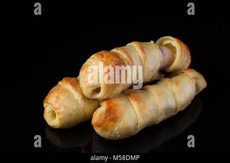 Bun with puff pastry with sausage on a dark background Stock Photo