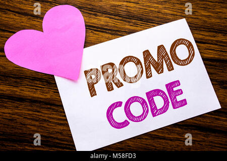 Conceptual hand writing text showing Promo Code. Concept for Promotion for Online Business written on sticky note paper, wooden background. With pink  Stock Photo