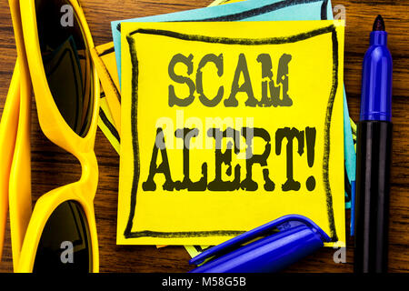 Hand writing text caption inspiration showing Scam Alert. Business concept for Fraud Warning Written on sticky note paper, wooden background vacation  Stock Photo