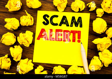 Writing text showing Scam Alert. Business concept for Fraud Warning Written on sticky note paper, wooden background folded yellow paper meaning thinki Stock Photo