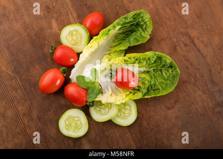 Vegetable: Fresh Green Romaine Lettuce with Baby Tomatoes, Mint Leaves and Cucumber Slices on Brown Wooden Background Stock Photo