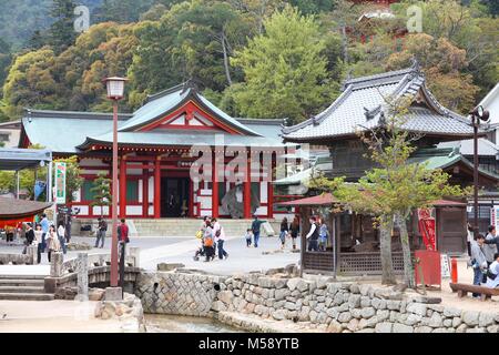 MIYAJIMA, JAPAN - APRIL 21, 2012: People visit Itsukushima Shrine in Miyajima. Famous island shrine is a UNESCO World Heritage Site and a major touris Stock Photo