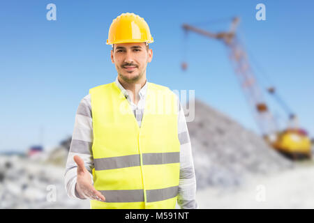 Friendly foreman or engineer giving offering handshake as deal gesture outdoors on construction site Stock Photo
