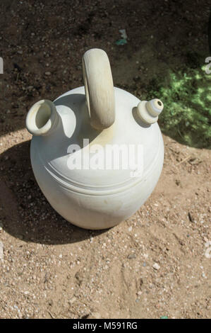 large ceramic Spanish clay jug resting on a dirt floor and seen from above Stock Photo