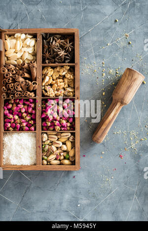 rustic wooden box full of oriental nuts, placed on gray table Stock Photo