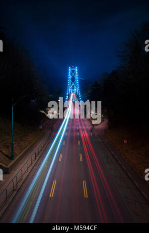 A photo of the lions gate bridge at night with cars driving. Stock Photo