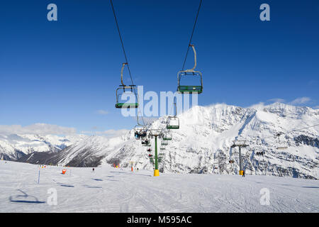 La Thuile, Italy - Feb 18, 2018: Chairlift at Italian ski area on snow covered Alps during the winter - winter sports concept Stock Photo