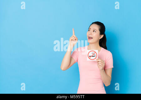 happy pretty girl having good idea about quit smoking when she standing in blue background. Stock Photo