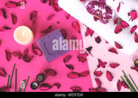 Orchid flower, potpourri, candle and lavender soap on pink background; Spa concept Stock Photo