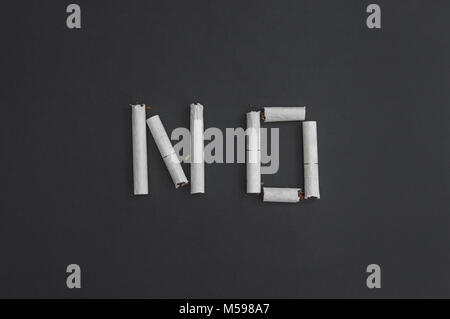No - an inscription word made from broken cigarettes to visualize the cessation of smoking. Against smoking - against cancer. Stock Photo