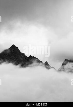 Kinner Kailash mountain range peeking through the heavy clouds Stock Photo
