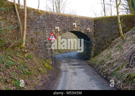 Height restriction sign by narrow stone bridge, Saddleworth, Greater Manchester, UK. Stock Photo