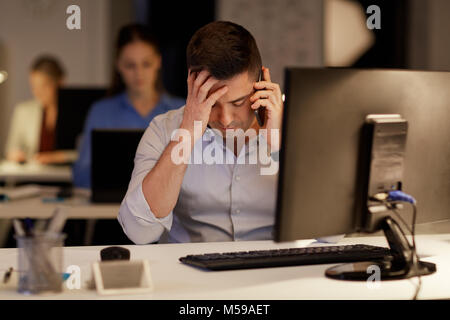 businessman calling on sartphone at night office Stock Photo