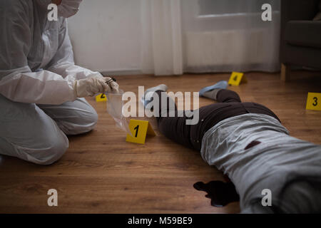 criminalist collecting crime scene evidence Stock Photo