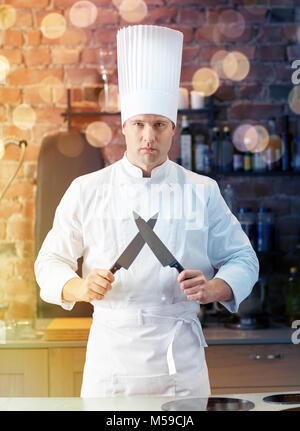 happy male chef cook in kitchen with knife Stock Photo