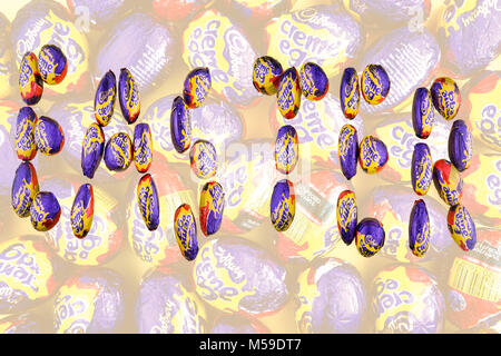 Cadbury creme eggs laid out to read Easter with more eggs in the background Stock Photo