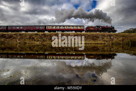 Bury, East Lancashire. 21st Feb, 2018. UK Weather.Another fine day for visitors riding on the volunteer run East Lancashire Railway today. A bumper crowd was expected to tour the line from Bury to Rawtenstall during the half-term holidays. Pulling the carriages was the locomotive 'The Crab' 13056. The train reflected in flooded fields near Burrs Country Park, Bury. Picture by Paul Heyes, Wednesday February 21, 2018. Credit: Paul Heyes/Alamy Live News Stock Photo