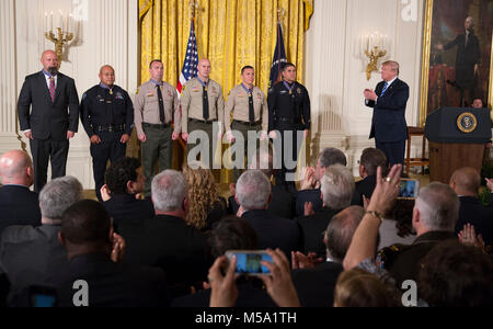 United States President Donald J. Trump applauds District Attorney Investigator Chad Johnson, San Bernardino County District Attorney's Office(left), Detective Brian Olvera, San Bernardino Police Department(2nd left), Deputy Shaun Wallen, San Bernardino County Sheriff's Department(3rd left), Detective Bruce Southworth, San Bernardino County Sheriff's Department(3rd right), Corporal Rafael Ixco, San Bernardino County Sheriff's Department(2nd right) and Officer Nicholas Koahou, Redlands Police Department(right) as recipients of the Public Safety Medal of Valor during a ceremony at The White Hous Stock Photo