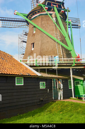 Two men painting and repairing windmill, Zaanse Schans a village near Zaandijk in the municipality of Zaanstad, North Holland, Netherlands. Stock Photo