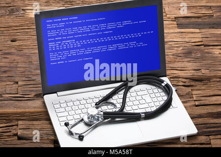 High angle view of stethoscope on laptop at wooden table Stock Photo