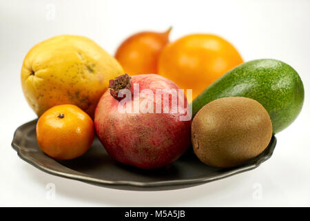 Exotic fruits - pomegranate, papaya, mango and other on a metal plate, on a white background Stock Photo