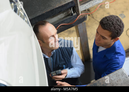 team of mechanics working together in workshop Stock Photo