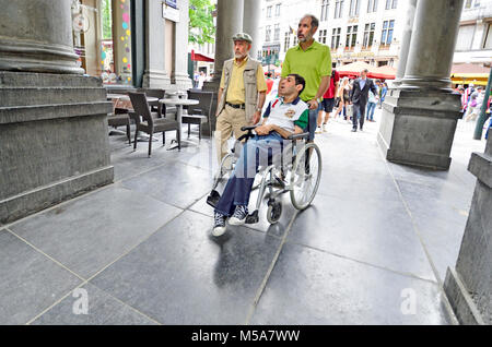 Brussels, Belgium. Disabled man in a wheelchair entering the Galeries Royales St Hubert Stock Photo