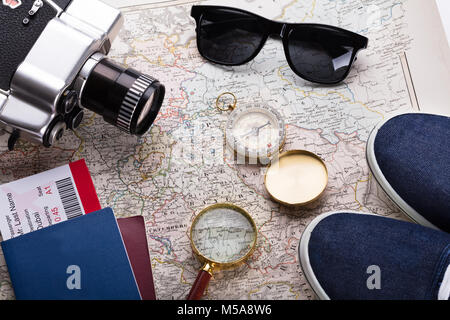 High Angle View Of Boarding Pass Ticket, Passport And Camera On Map Stock Photo
