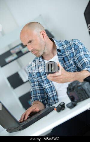 man looking at broken photographic lense Stock Photo
